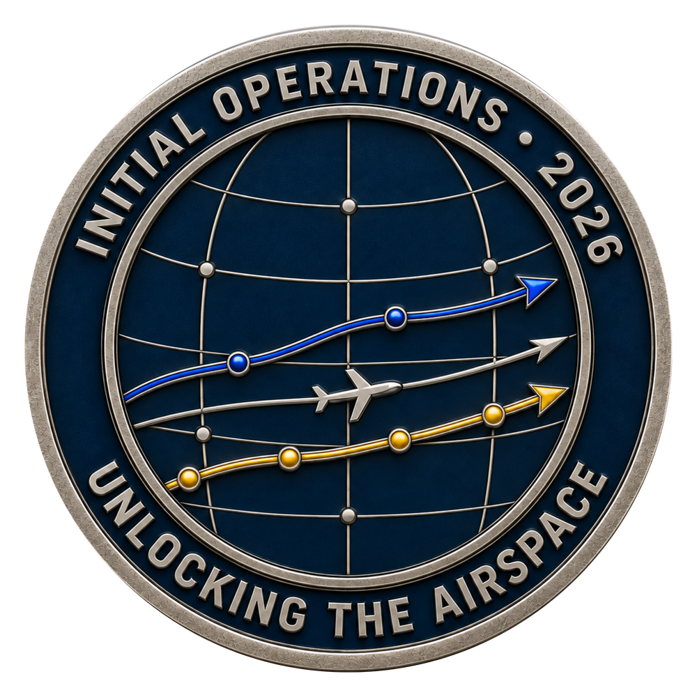 A circular commemorative coin or medallion with a dark blue globe design, silver-toned border and text reading 'INITIAL OPERATIONS • 2026' and 'UNLOCKING THE AIRSPACE,' plus blue, gray, and gold flight-path graphics and a small airplane icon.